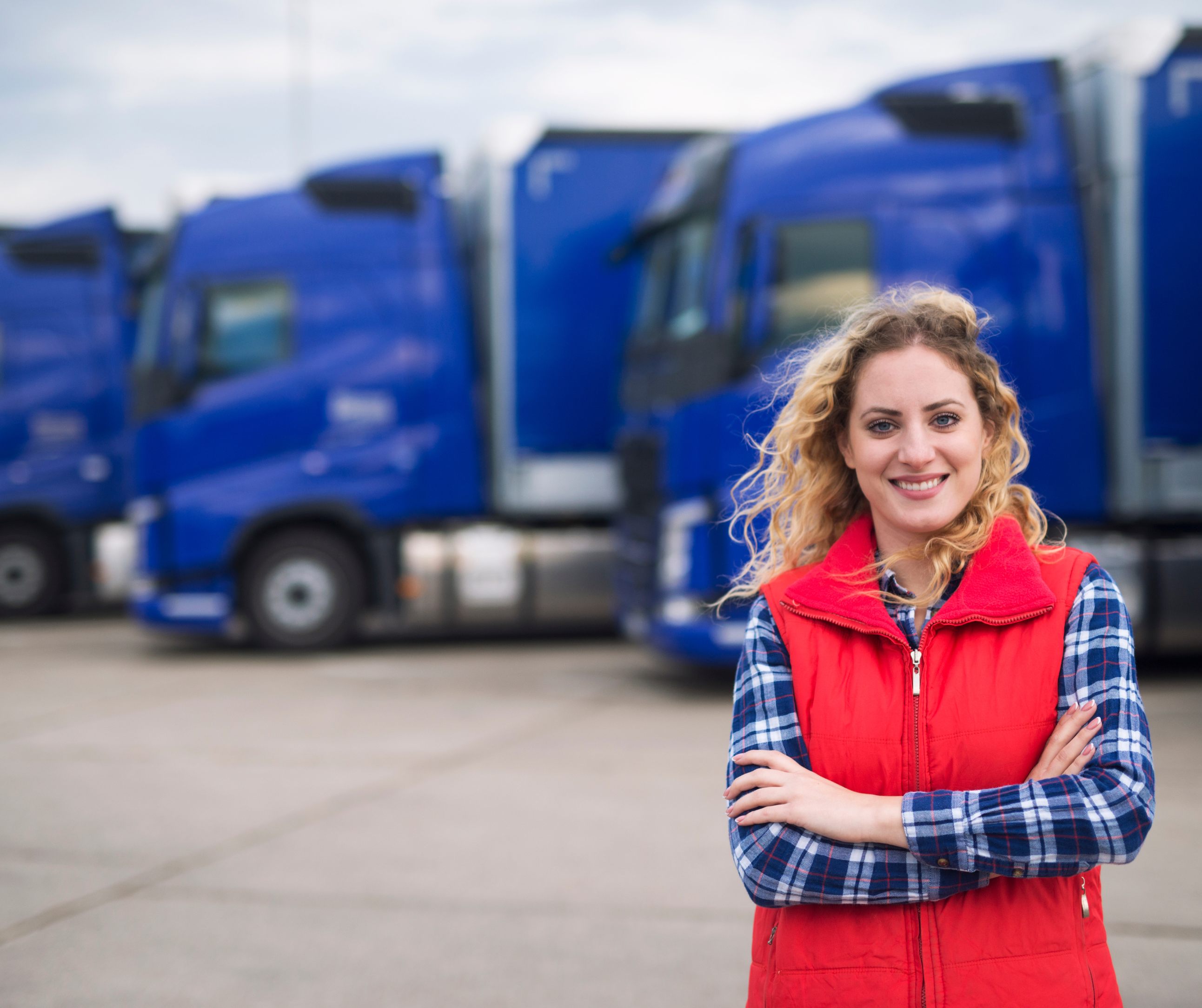női kamionsofőr a kamionok előtt