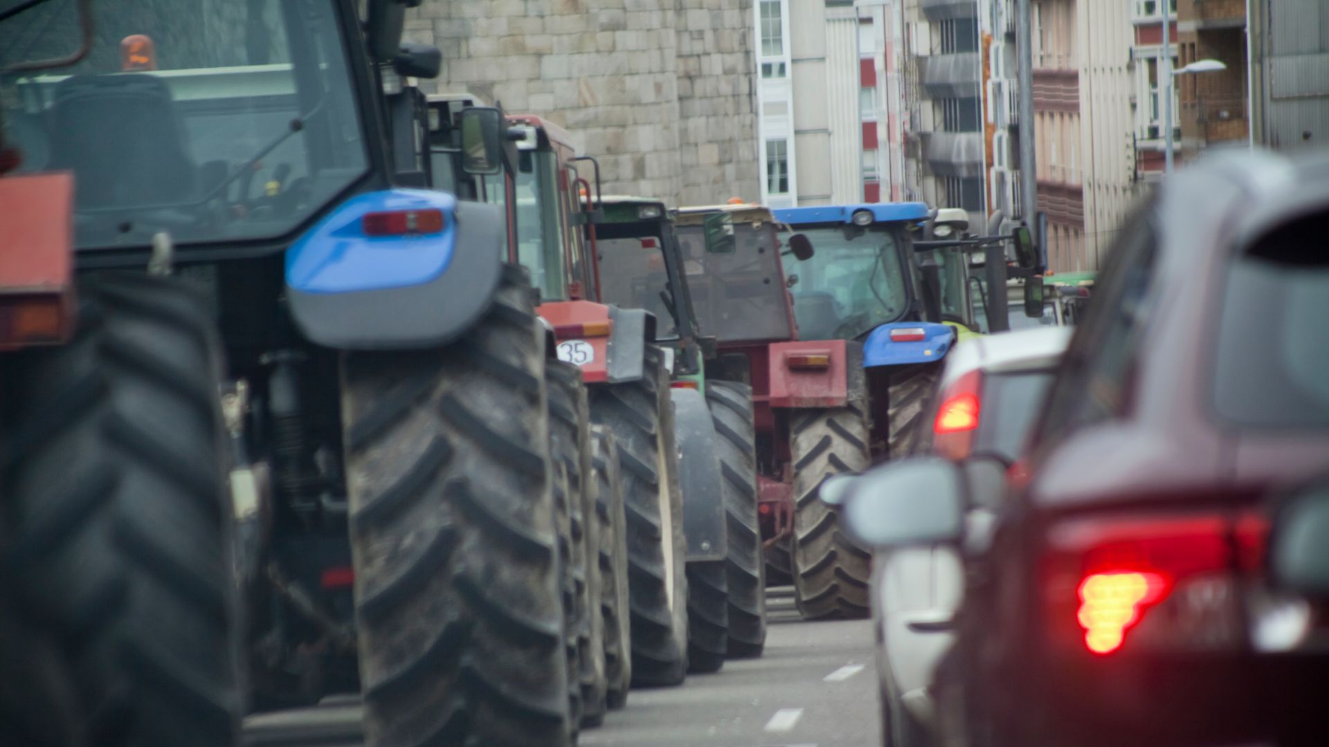 Az úton több traktor libasorban helyeszkedik el.