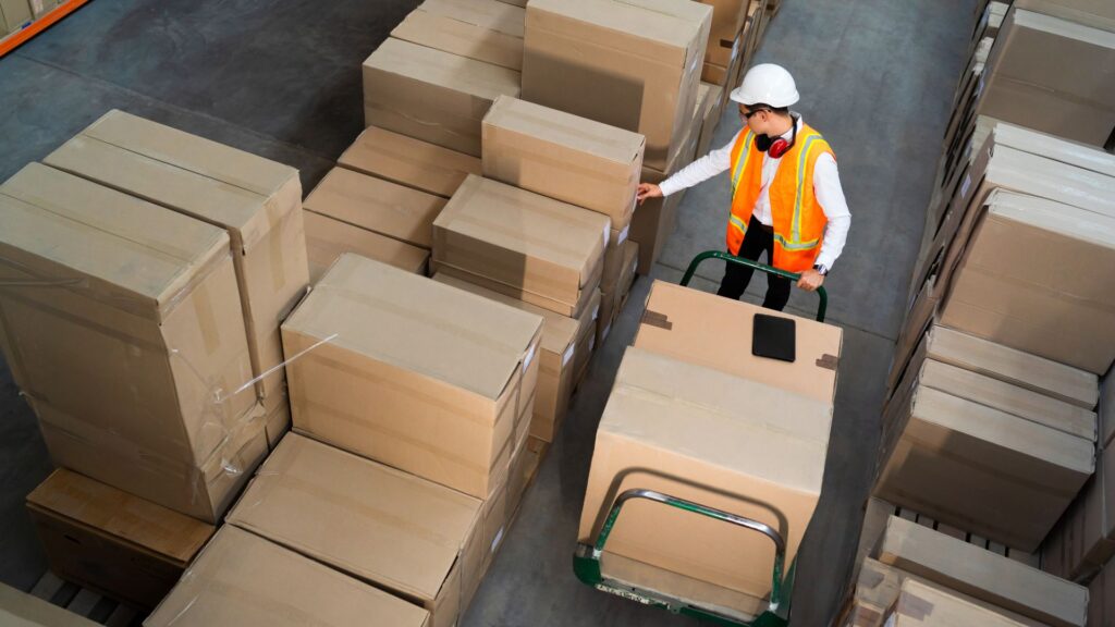 Egy logisztikai központban egy muntárs a csomagokat pakolja össze.